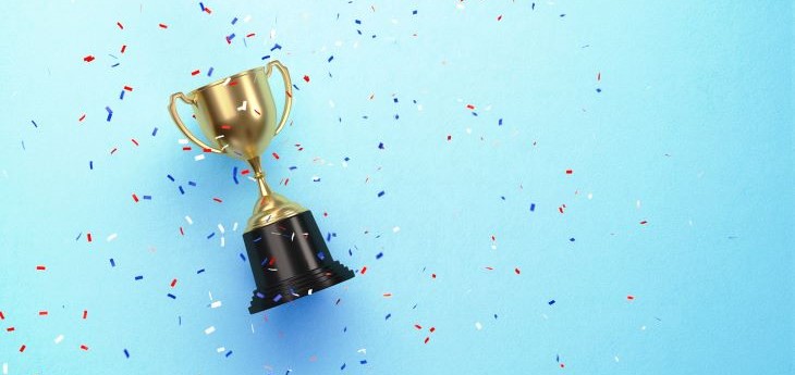 Award trophy with confetti against a light blue background.